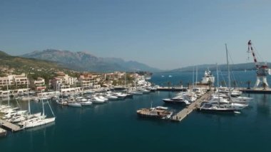 Tivat 'taki Porto Karadağ marinası, rıhtımdaki yatlar, vinç ve otel kompleksi manzarası 