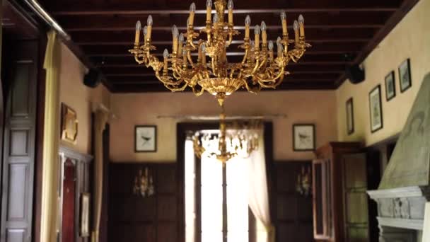 The interior of an old Italian villa, large windows and a large golden chandelier with candles. — Stock Video