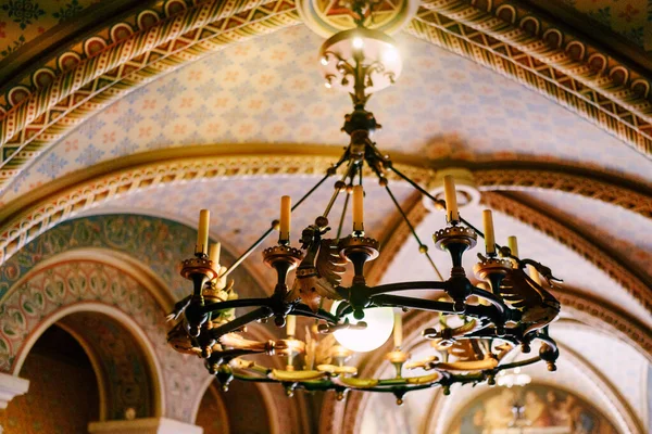 Medieval chandelier with wax candles. Metal chandelier in a castle style with real candles. — Stock Photo, Image