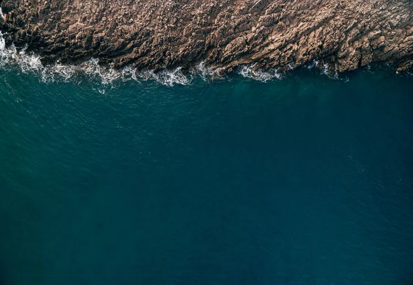 Pedras, ondas turquesa e espuma do mar de cima. Costa atlântica com rochas. Fotografia aérea de drones. Bela paisagem. Cenário ao ar livre fundo. — Fotografia de Stock