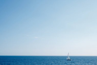 Mavi gökyüzüne karşı açık denizlerde yelken açan gemi