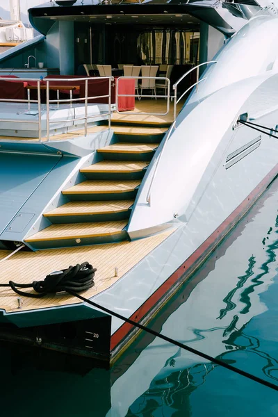 Widok z boku na rufę trałowania pięknego jachtu motorowo-białego zacumowanego na molo — Zdjęcie stockowe