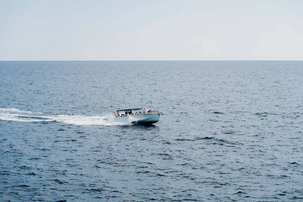 Yate de motor con turistas a bordo velas en alta mar — Foto de Stock