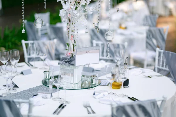Пустая тарелка стоит на красиво сервированном праздничном столе, покрытом белой скатертью — стоковое фото