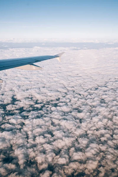 Vue de la fenêtre de l'avion sur les cumulus blancs au-dessous — Photo