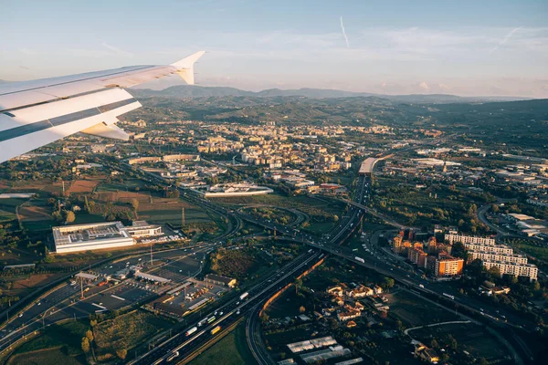 Vue depuis la fenêtre de l'avion d'une ville moderne avec des immeubles de grande hauteur, des autoroutes des transports et des espaces verts — Photo