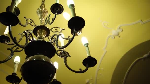Lámpara de araña de metal negro de estilo barroco con lámparas de techo y velas. — Vídeo de stock