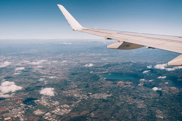 Vue de la fenêtre de l'avion de la ville à travers les nuages blancs — Photo