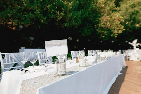 Signo vacío se encuentra en una mesa de vacaciones bellamente servida cubierta con un mantel blanco — Foto de Stock