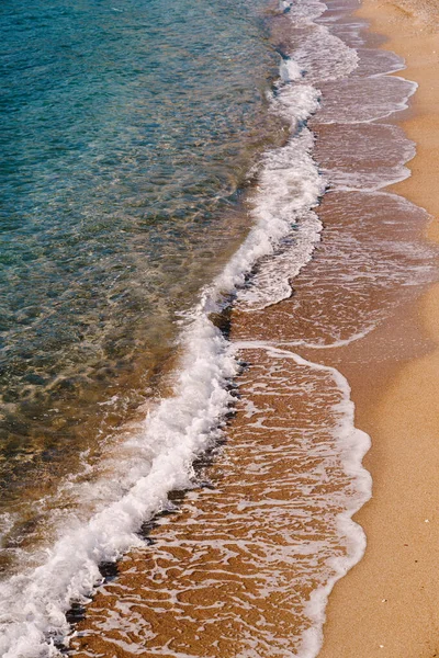Ondas marinas en el fondo de una playa de arena. Vista lateral — Foto de Stock