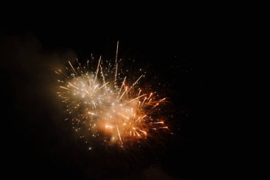 Karanlık gece gökyüzünde renkli havai fişekler patlar