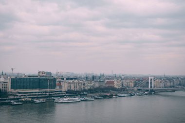 Tuna Nehri üzerindeki köprünün Budapeşte 'deki eski evlerin arka planına bakışı
