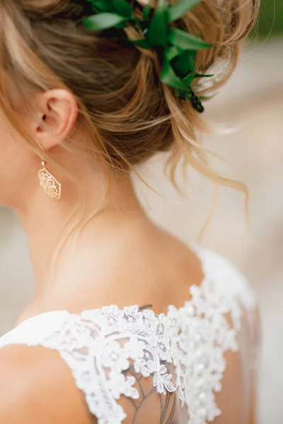 Sposa bionda in abito di pizzo con un grazioso orecchino nell'orecchio e una corona di ulivi, primo piano — Foto Stock