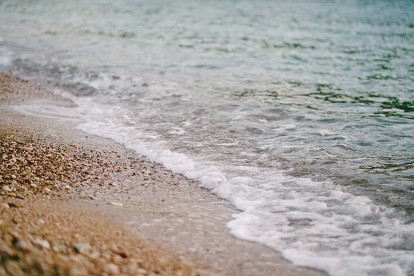 Pianka morska toczy się na piasku na plaży — Zdjęcie stockowe