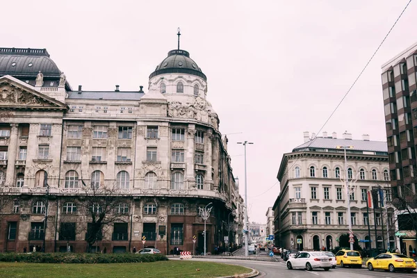 Starověké ulice v Budapešti. Auta jedoucí po silnici na pozadí krásných budov — Stock fotografie