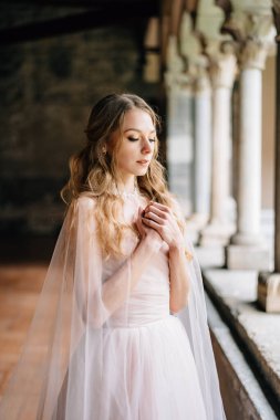 Gelin, Como Gölü 'ndeki eski bir villada kolları bağlı bir şekilde göğsünde duruyor. Kapat.