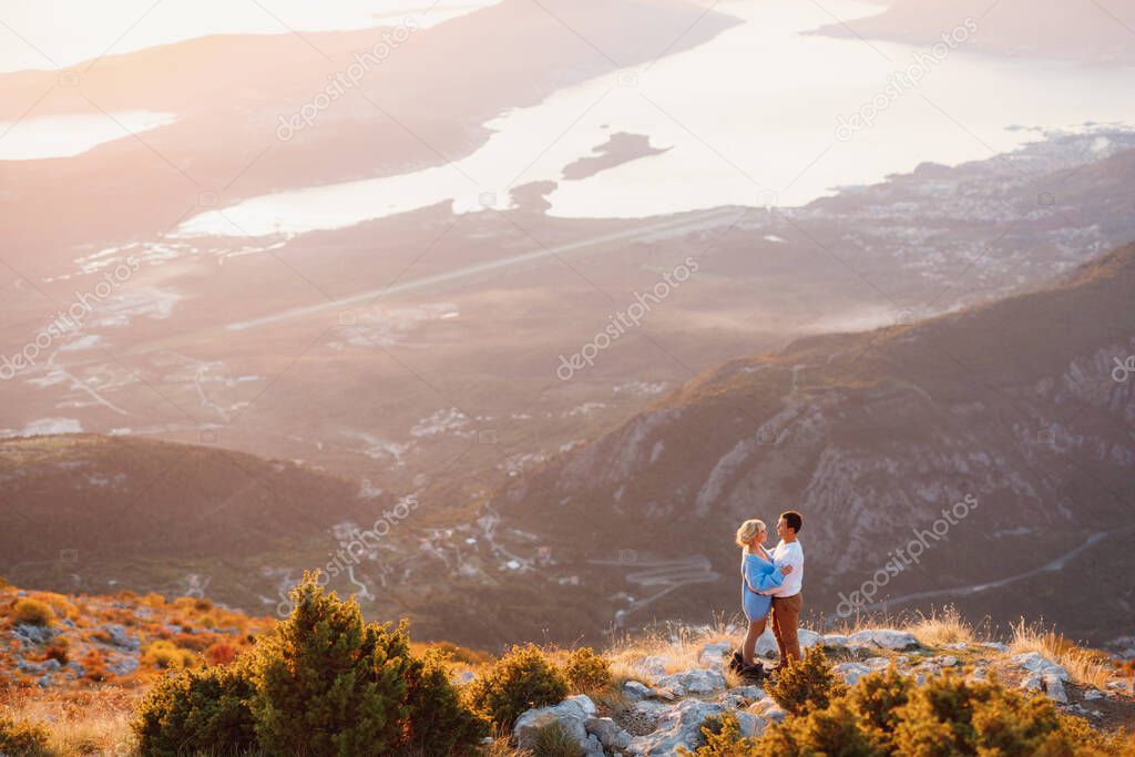 Couple hugging on the background of the panorama of Lovcen mount , Montenegro