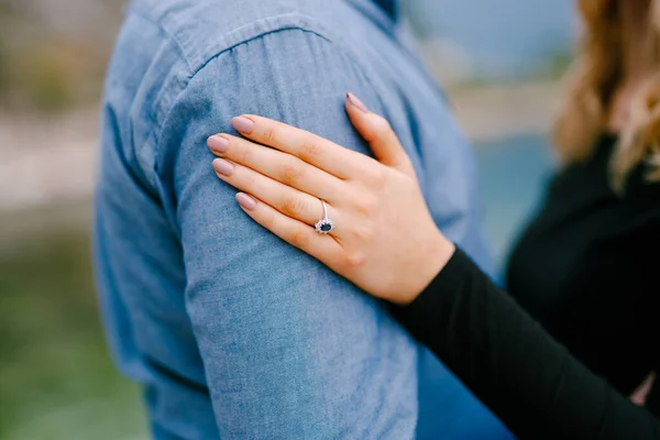 La chica puso su mano con un anillo en el hombro del hombre. De cerca. —  Fotos de Stock