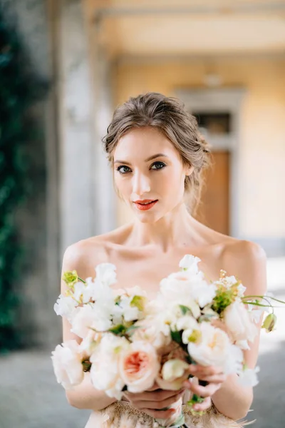 Portrait of serious bride in a dress with a bouquet of pink flowers in the vaulled room. Danau Como, Italia — Stok Foto