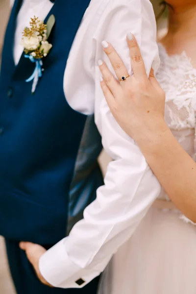 Braut in einem wunderschönen Kleid legte ihre Hand auf die Schulter des Bräutigams — Stockfoto