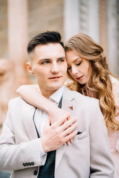 Serious newlyweds hug on the steps at the entrance to the Basilica of Santa Maria Maggiore in Rome. Half portrait — Stock Photo, Image