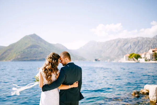 Feliz novia sonriente y novio abrazándose en el fondo de un hermoso paisaje de montaña en un día soleado. — Foto de Stock