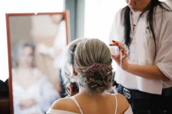 Stylist rende la sposa di fronte allo specchio una bella acconciatura — Foto Stock