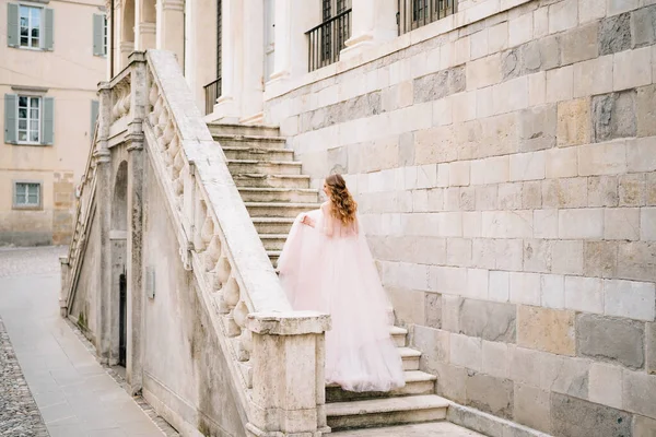 Noiva em um vestido bonito sobe os degraus de um edifício antigo em Bergamo, Itália — Fotografia de Stock