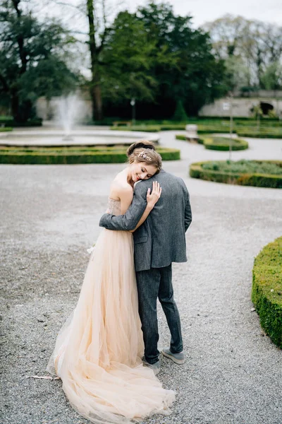 Наречена відпочила головою на плечі нареченого, обійнявши її в парку. Озеро Комо, Італія — стокове фото