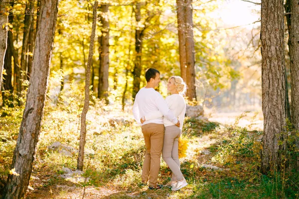 Man och kvinna omfamnar varandra i höstskogen. Bakifrån — Stockfoto