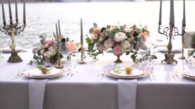 Kotor Körfezi 'ndeki iskelede çiçeklerle, şamdanlarla ve genç narlarla süslenmiş bir düğün yemeğinde bir masa.