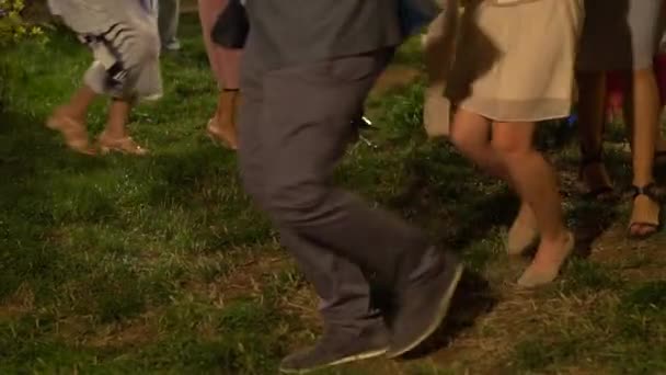 Люди делают линию конга на вечеринке под открытым небом — стоковое видео