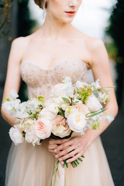 Pengantin dalam gaun yang indah memegang karangan bunga di tangannya — Stok Foto