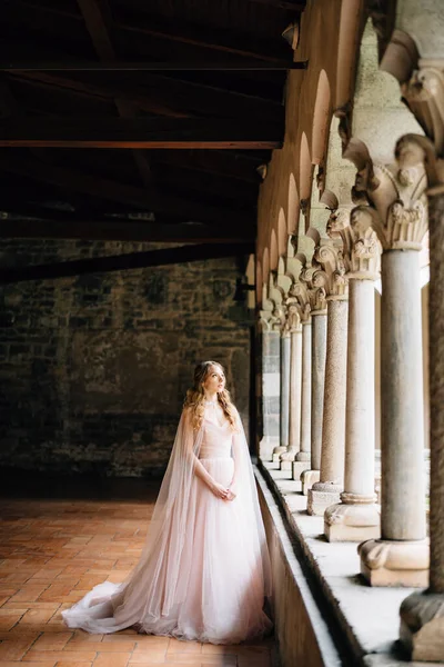 Novia se encuentra cerca de las columnas en el balcón de una antigua villa en el lago de Como, Italia —  Fotos de Stock