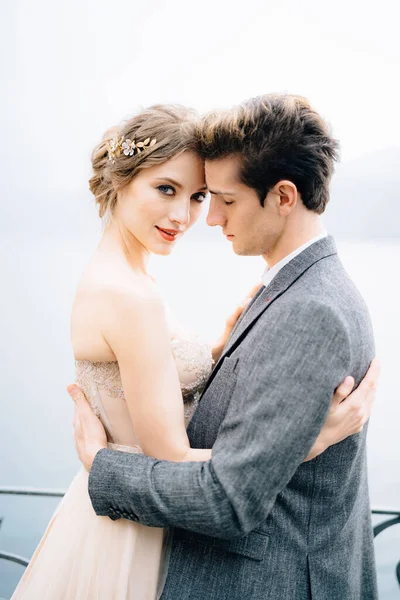 Recém-casados abraçar contra o pano de fundo do Lago de Como. Fechar — Fotografia de Stock