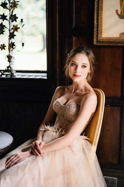 Νύφη σε ένα όμορφο φόρεμα κάθεται σε μια καρέκλα σε ένα τραπέζι σε ένα παλιό κτίριο με φόντο έναν πίνακα ζωγραφικής. Λίμνη Κόμο — Φωτογραφία Αρχείου