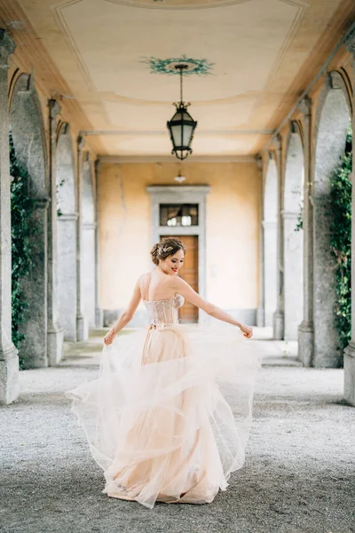 Noiva sorridente em um vestido de noiva gira em um velho terraço com pilares. Lago de Como — Fotografia de Stock