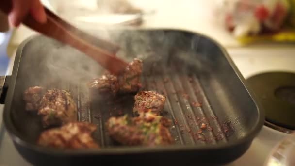 生ステーキの塊がホットグリルパンにドロップされます。背景にあるグリルパンと煙の上で生牛ステーキの落下のクローズアップ. — ストック動画