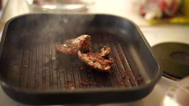 Färskt nötkött kött på tända pan, närbild. Matlagning nötkött biff på stekpanna, läckra biffar steks på en grillpanna. — Stockvideo