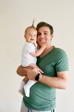 Gülümseyen baba kucağında gülümseyen bir bebek tutuyor. Portre