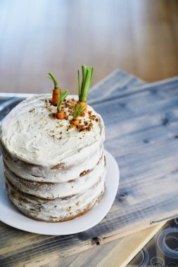 Havuçlu kek masada beyaz bir tabağın üzerinde duruyor. Yukarıdan görüntüle