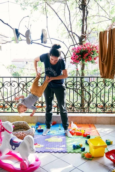 Ibu batu anak kecil terbalik di balkon — Stok Foto