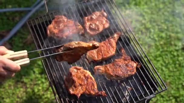 Lo chef ribalta le bistecche con le pinze alla griglia. — Video Stock