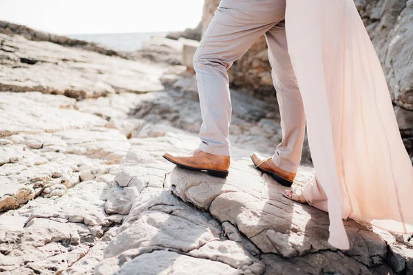 Legs of lovers man and women standing on the rocks next to each other, close-up —  Fotos de Stock