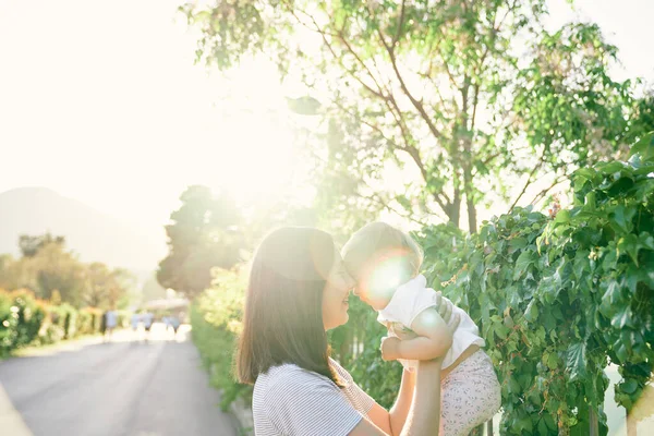 Mamma alzò una bambina tra le braccia al recinto, intrecciata con edera — Foto Stock