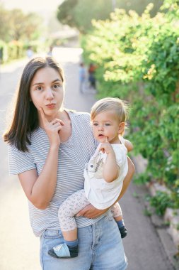 Annem yüzünü asar ve sarmaşıkla sarmalanmış küçük bir kızı kollarına alır.