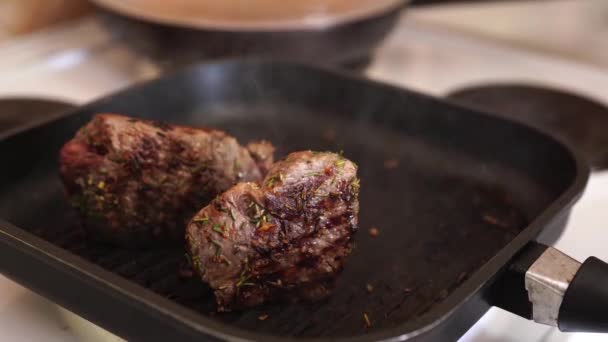 Um pedaço de bife cru é colocado numa panela quente. Close-up de queda de bife de carne crua na panela de grelha e fumaça no fundo. — Vídeo de Stock