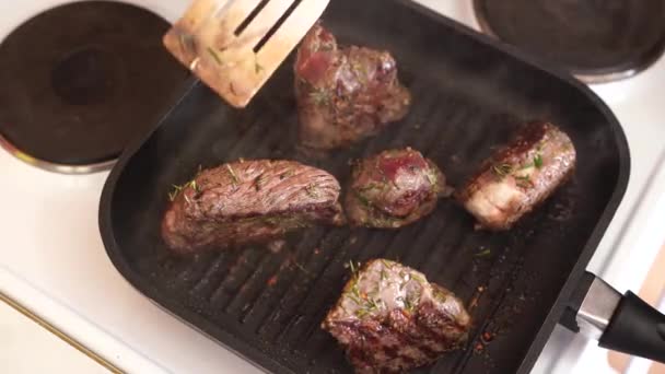 O processo de cozinhar um bife em uma panela de ferro fundido. O cozinheiro prepara um prato de carne. — Vídeo de Stock