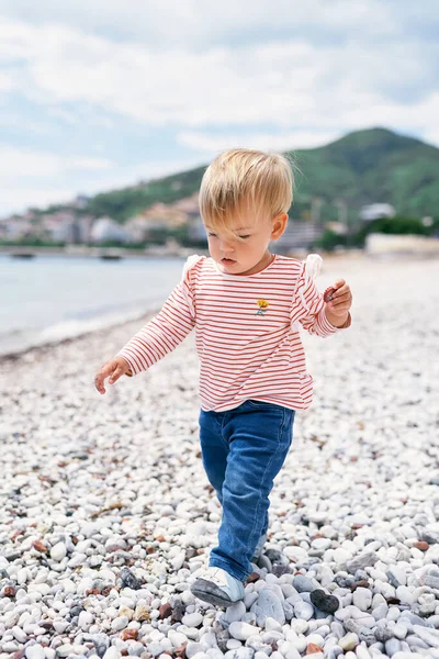 Anak kecil berjalan di sepanjang pantai melihat kakinya — Stok Foto