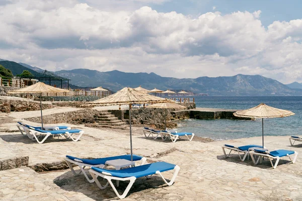 Pantai CobbIed dengan ruang tunggu matahari dan payung dekat laut — Stok Foto